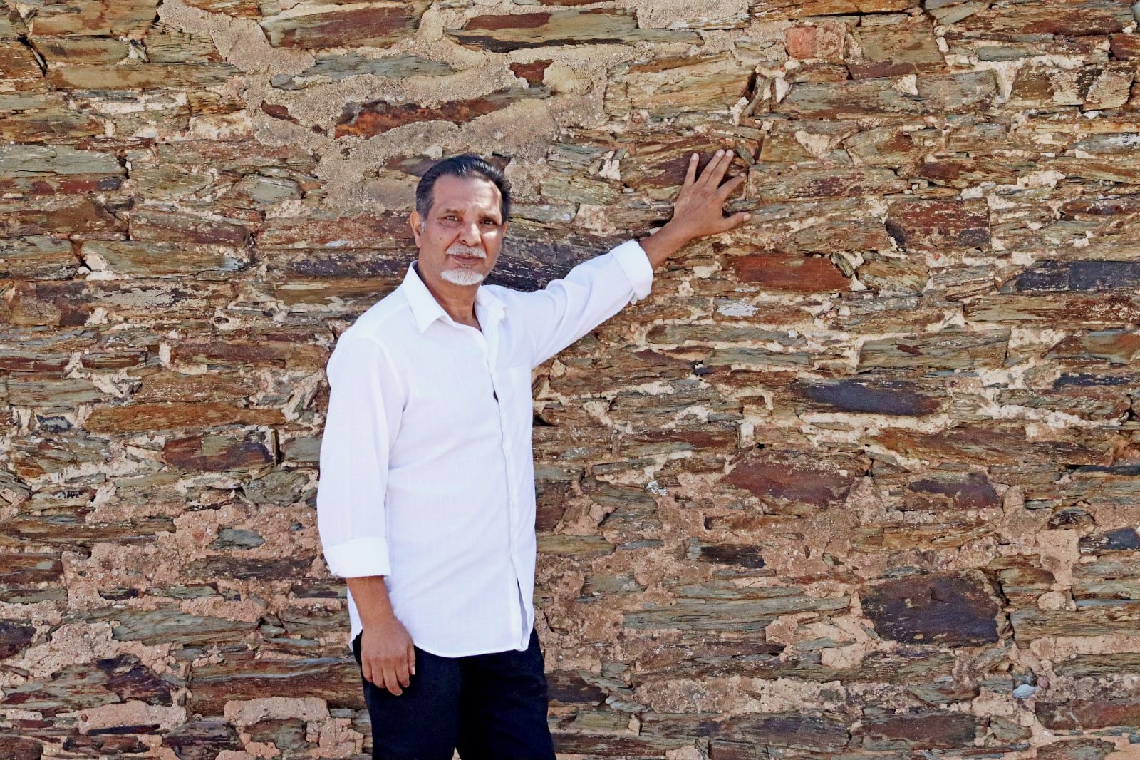 Julián Cortés junto a un muro de piedra histórico